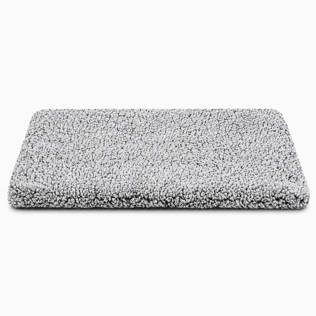 Tapis chauffant chien avec surface souple grise dans un panier, créant un espace douillet pour le repos