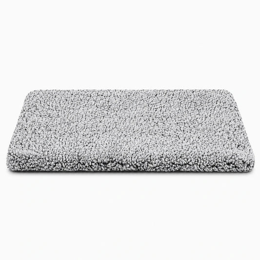 Tapis chauffant chien avec surface souple grise dans un panier, créant un espace douillet pour le repos