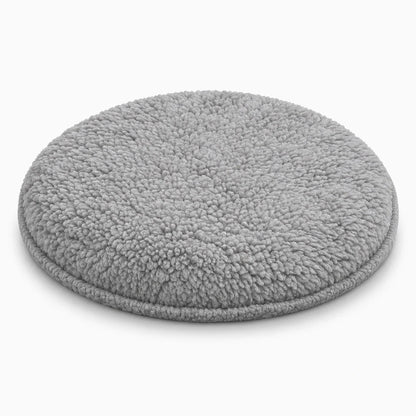 Petit lapin assis sur le tapis rond gris, coin douillet de la cage